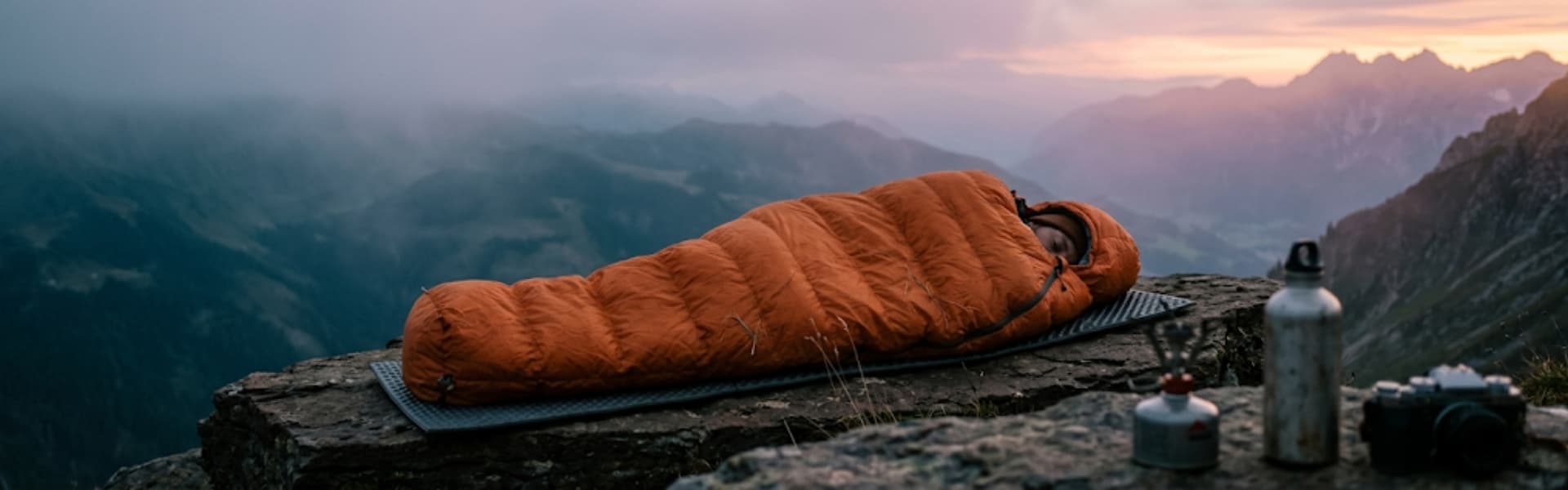 Schlafsack im Biwak bei Dämmerung — Gipfeltest aggregiert Tests deutschsprachiger Outdoor-Magazine, EN-ISO-Daten und Nutzererfahrungen zu Daunen- und Kunstfaserschlafsäcken